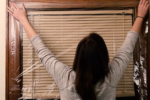 Woman applying shrink wrap film to a window