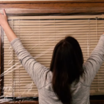 Woman applying shrink wrap film to a window